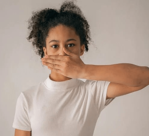 Image: Woman with hand covering her mouth. Source: Pexels.com