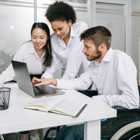 Coworkers Looking at a Laptop in an Office