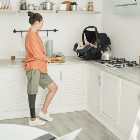 mom with prosthetic leg cooking in the kitchen with her kid
